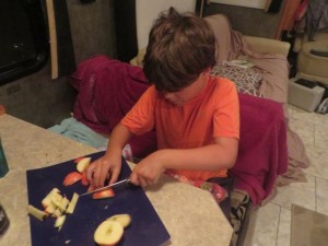 Cutting up apples for his fruit salad.