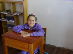 Kat sitting at her desk in the classroom. 