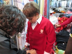 Kane trying on his sweater for his school uniform. 